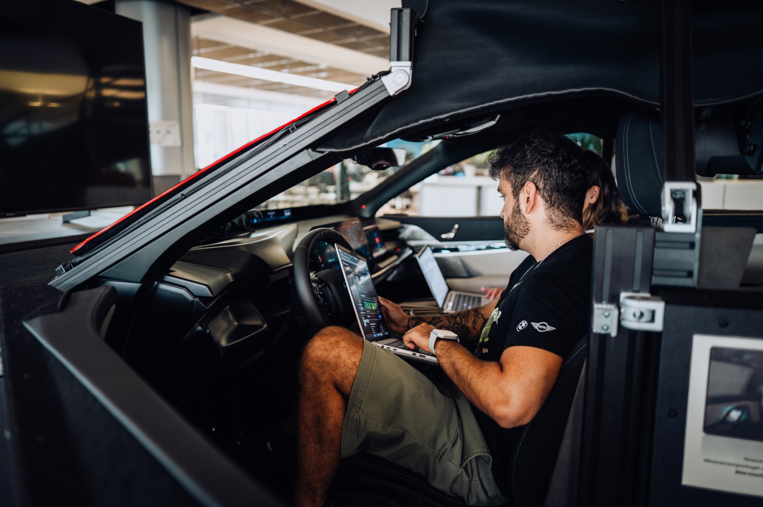 BMW software architect Matheus in a vehicle mockup at the research center