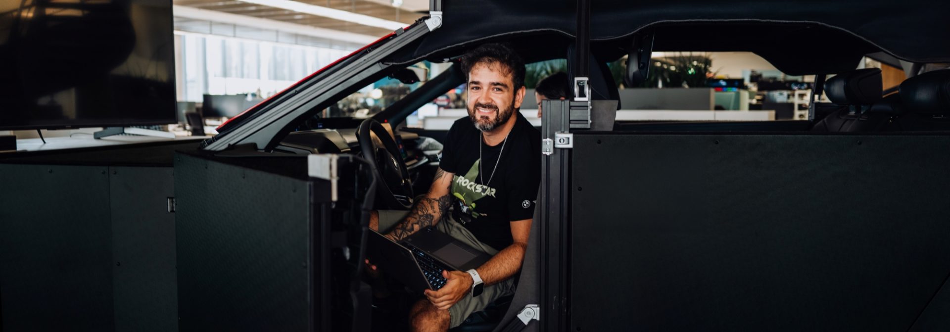 BMW software architect Matheus in a vehicle mockup at the research center