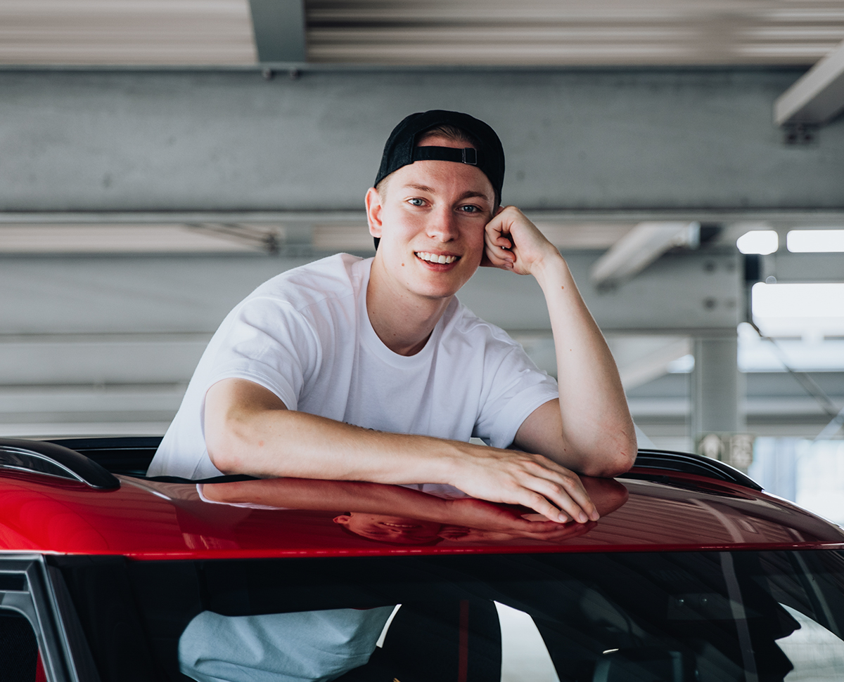 Student standing in a MINI Countryman leaning out of the window in the roof of the car.