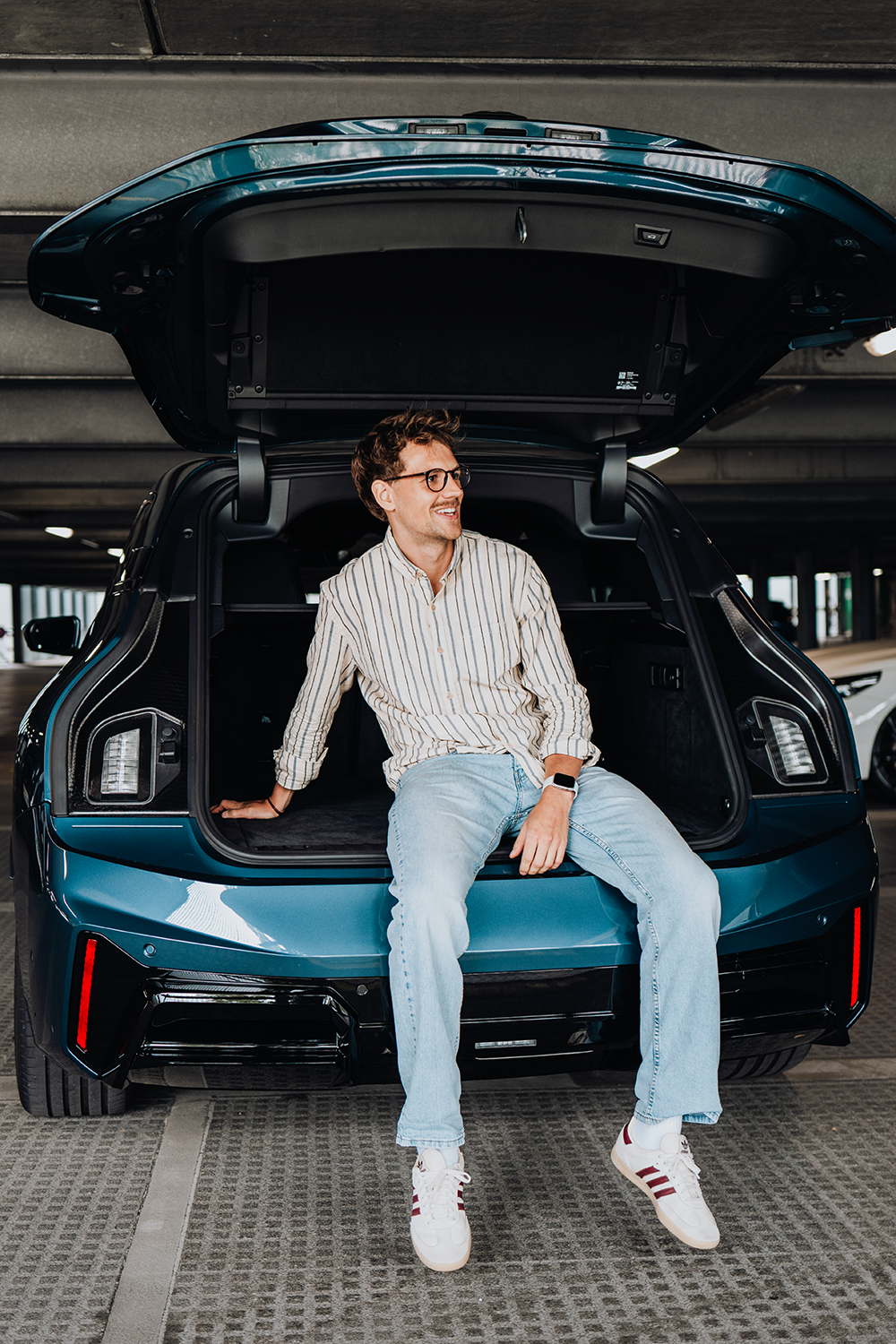 PhD student phillips sits in the trunk of the BMW iX.