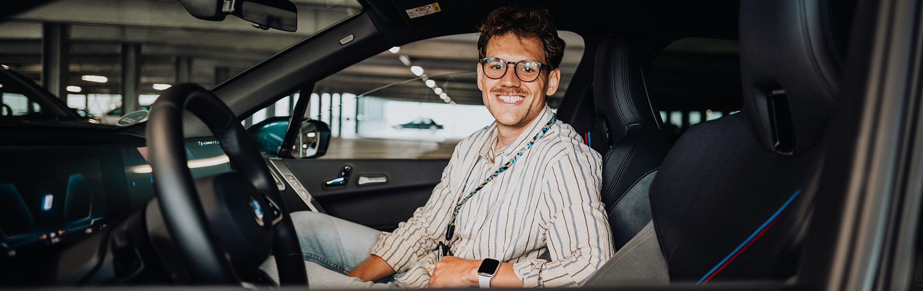 PhD student Phillip in the passenger seat of a BMW iX