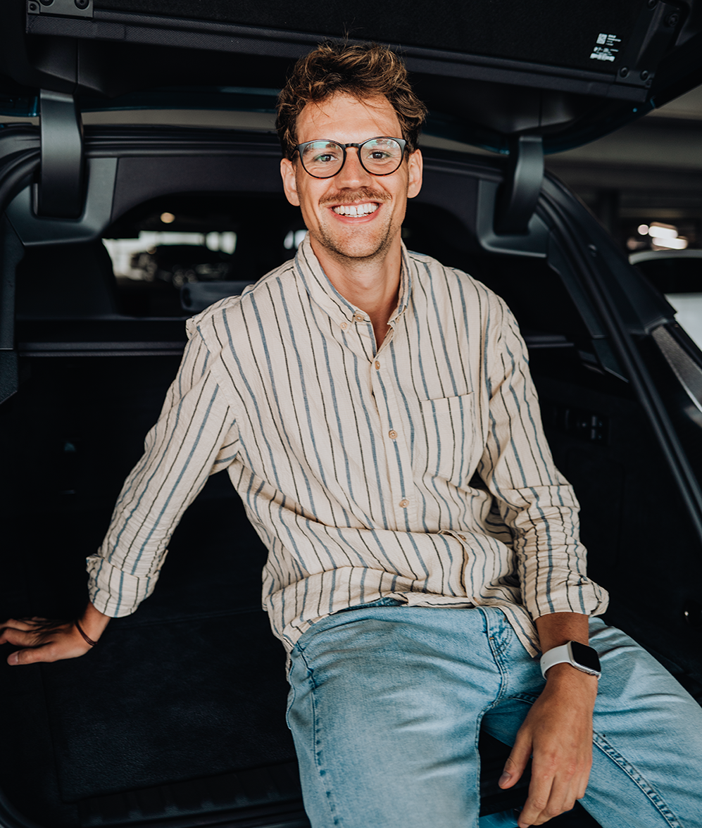 PhD student Phillip laughs in the trunk of the BMW iX.