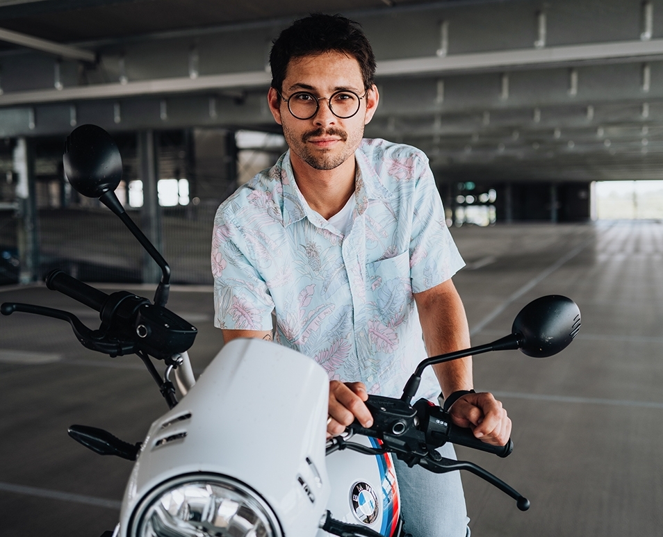 The employee sitting on his motorcycle leaning forward.