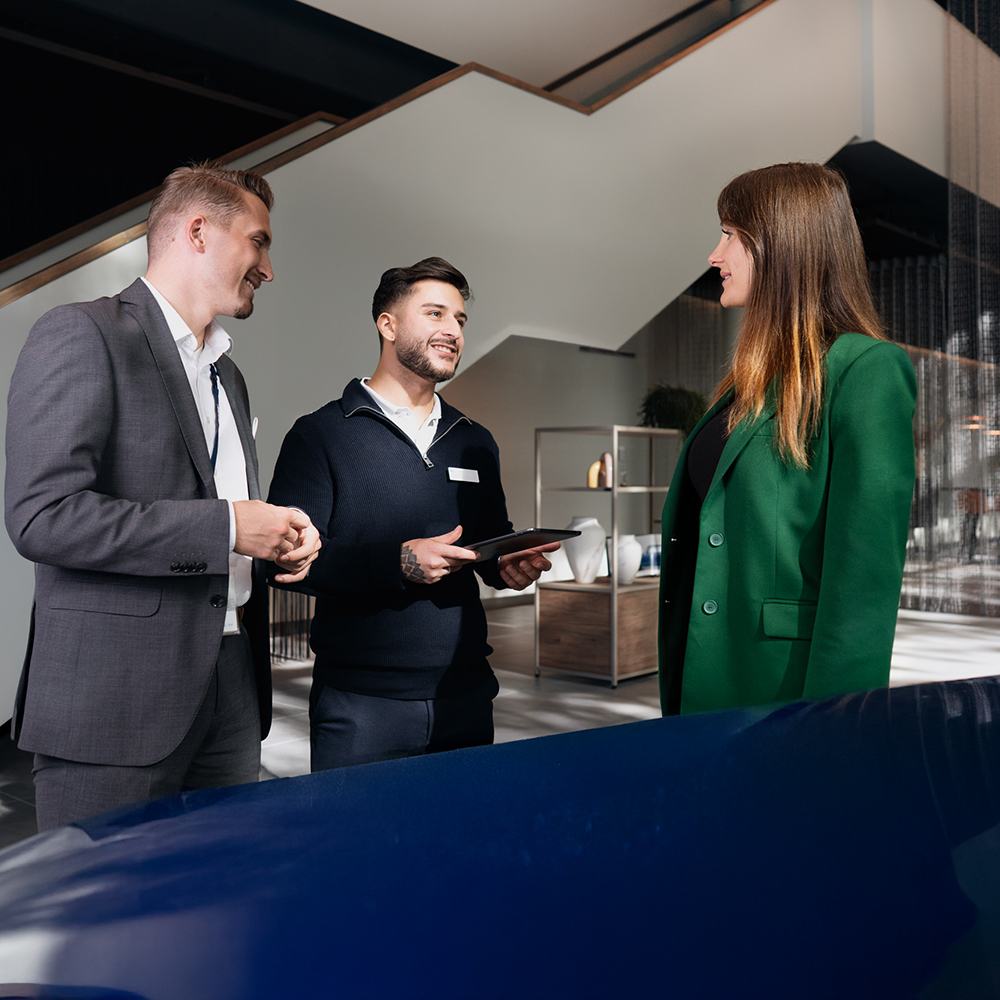Engaging sales experience at a MINI dealership with a red car in the background.