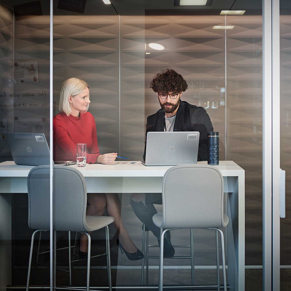 BMW employees discussing strategy and development in a modern office setting.
