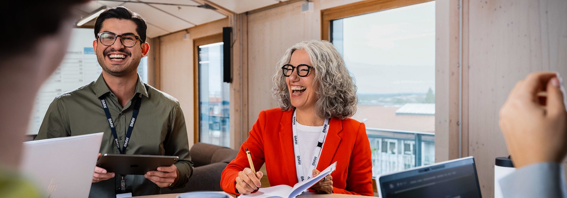 HR employees laughing heartily in a meeting