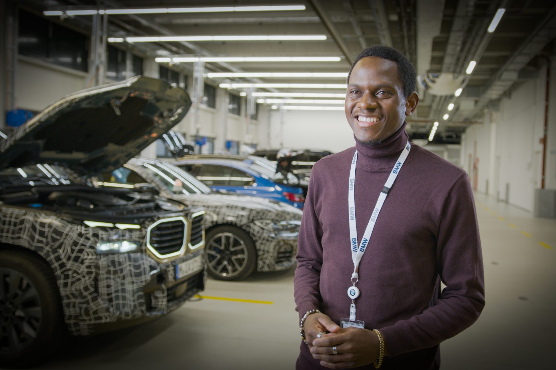 A IT specialist at the BMW Group next to new Cars.