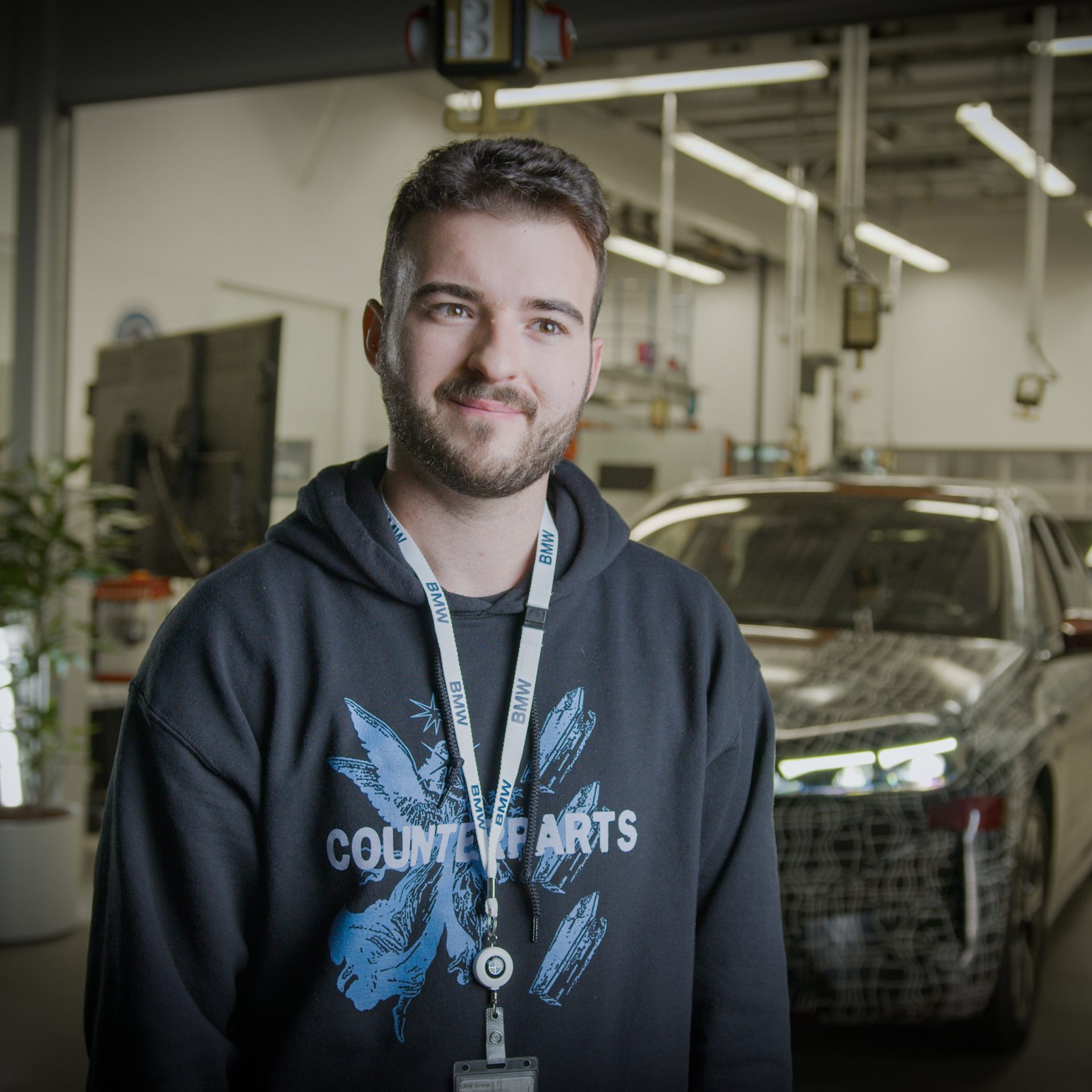 A cyber security specialist next to a BMW Vehicle.