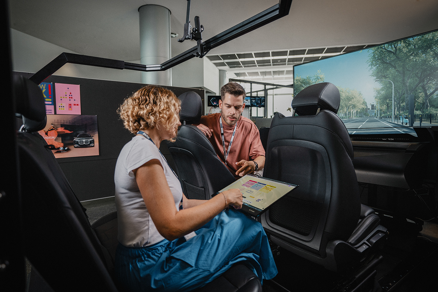 Two colleagues working inside a driving simulator