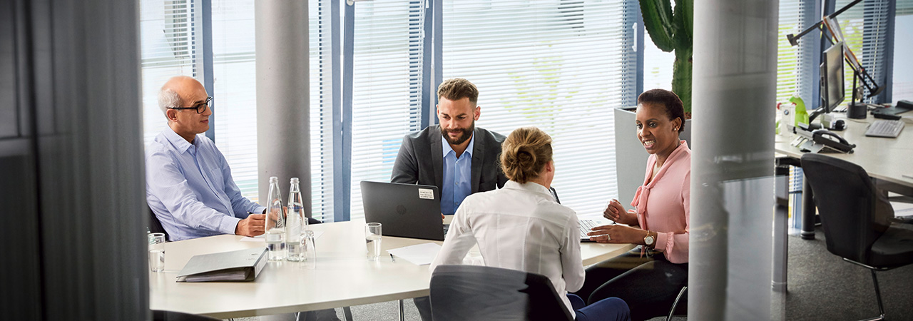 Employees in Legal Services, IP and Compliance sitting together in a Meeting.
