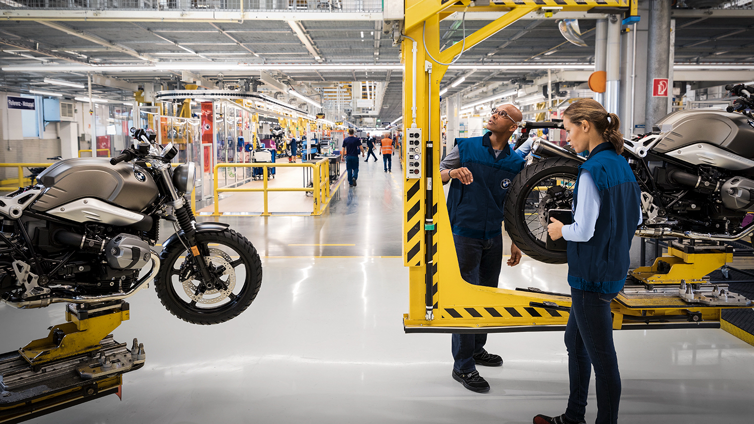 Two employees in production working on a motorcycle.