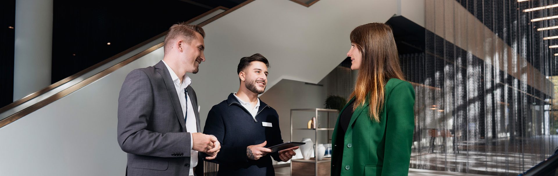 A kind salesperson in a BMW car dealership having a conversation with a customer.