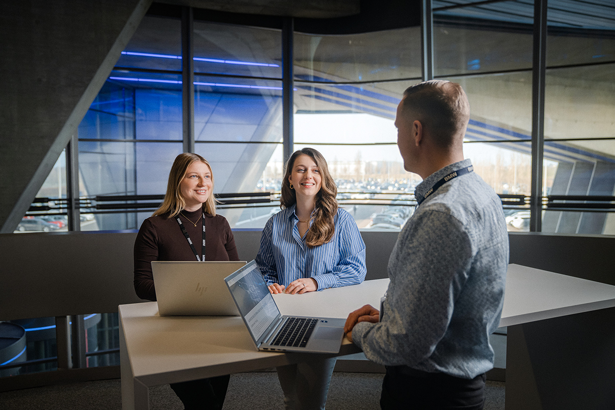 Two female colleagues in conversation with a male colleague