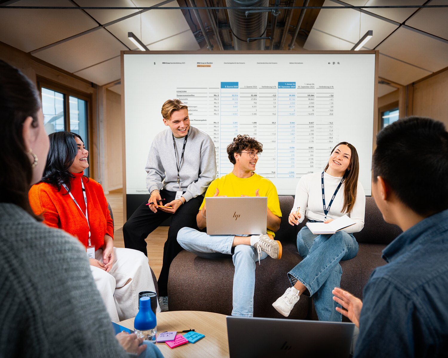 A group of students having a conversation in a modern office environment