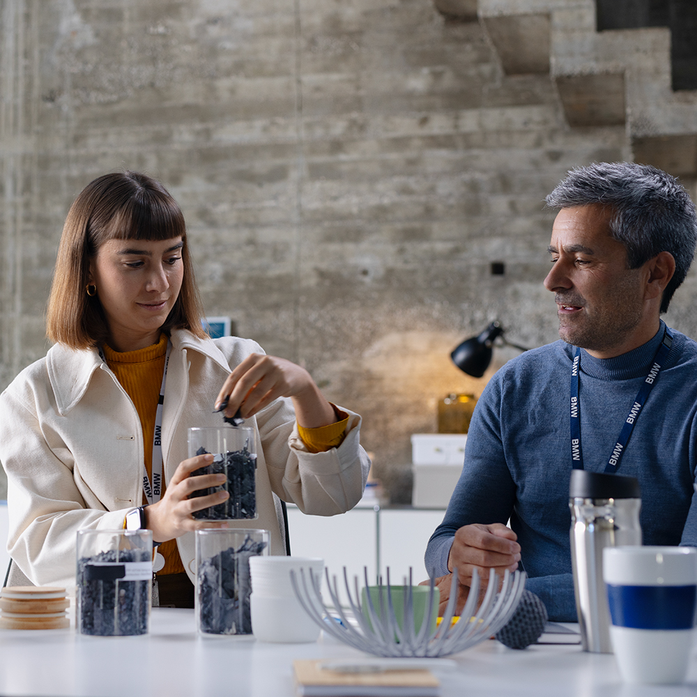 Two BMW employees discuss sustainable materials at BMW.