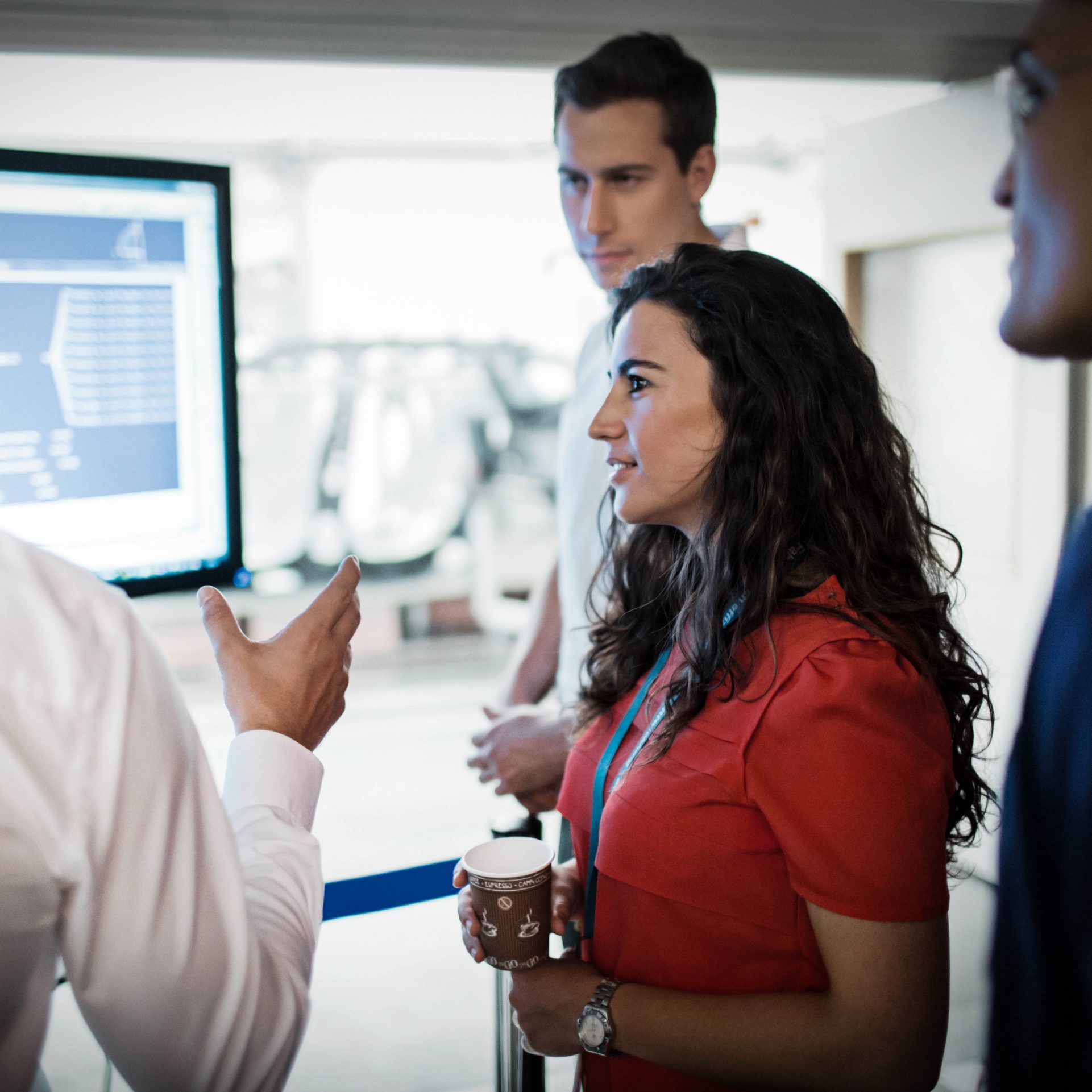 Four BMW professionals, having a discussion about a diagramm shown on the computer screen.