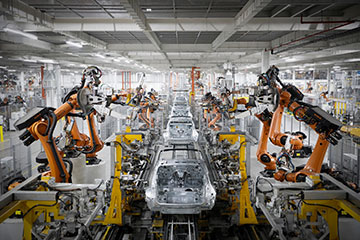 A robotic assembly line with multiple robotic arms working on car manufacturing.