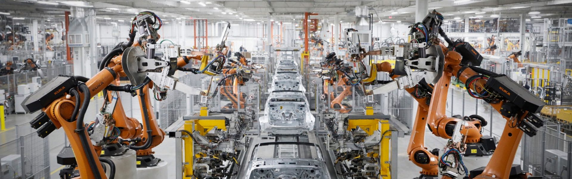 A robotic assembly line with multiple robotic arms working on car manufacturing.