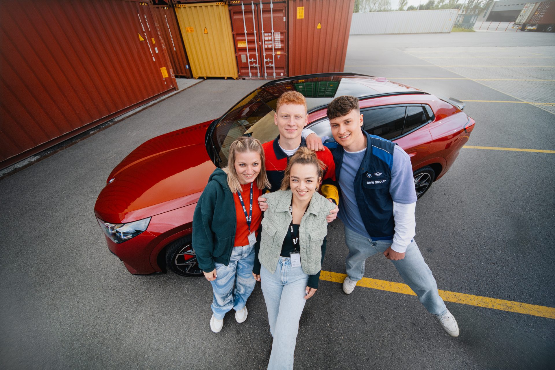 Vier Azubis vor einem roten BMW X2
