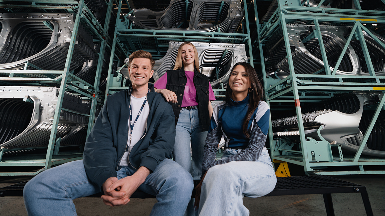 Drei Azubis vor einem Hochregallager