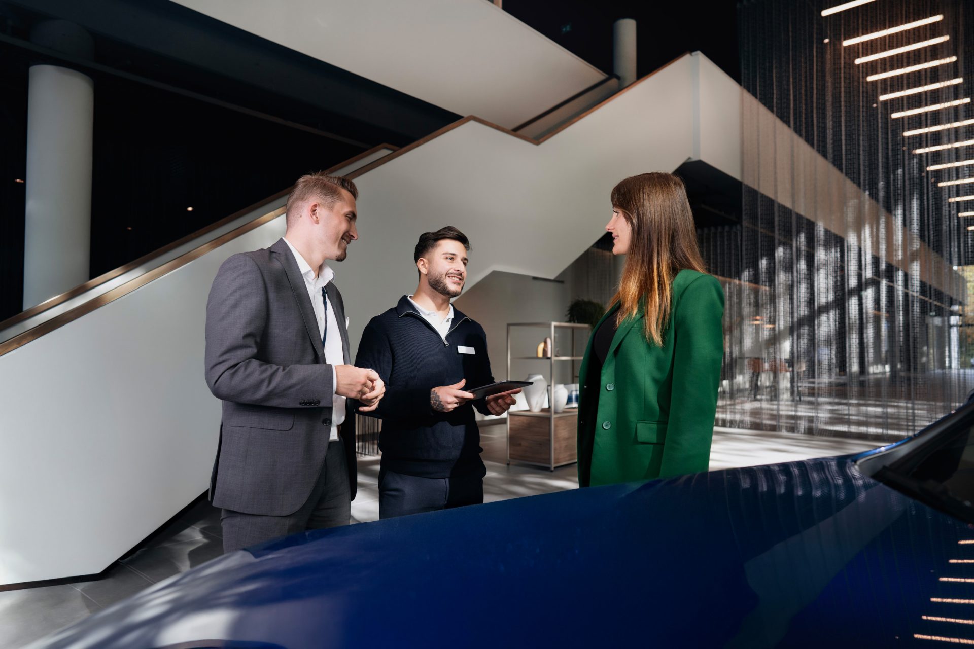 Two sales advisors in conversation with a customer.