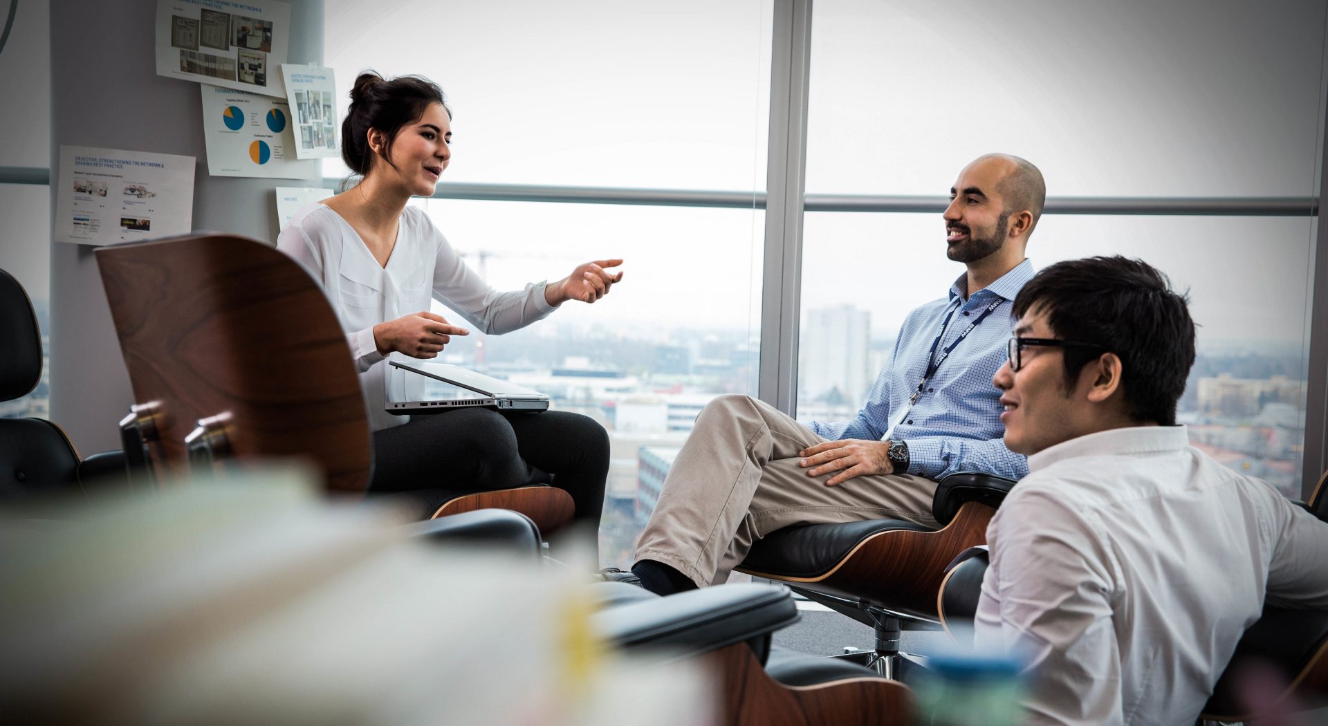 A Student and two BMW employees are sitting together and have a conversation.