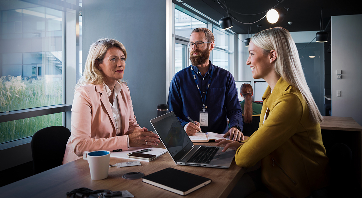 Two women and a man in a conversiation at a BMW office.