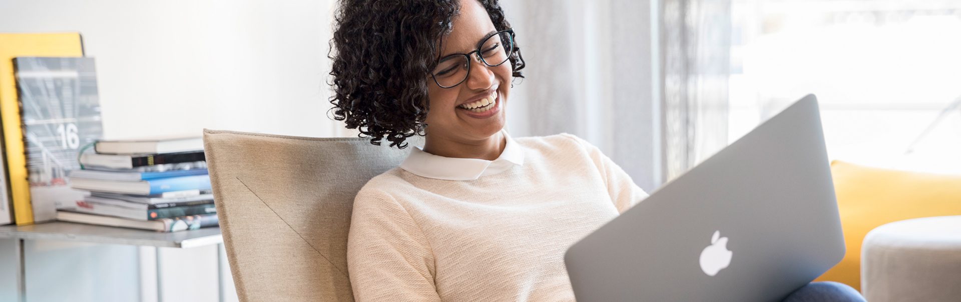 A BMW employee working on her computer, laughing.
