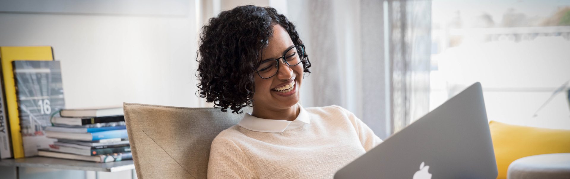 A BMW employee working on her computer, laughing.