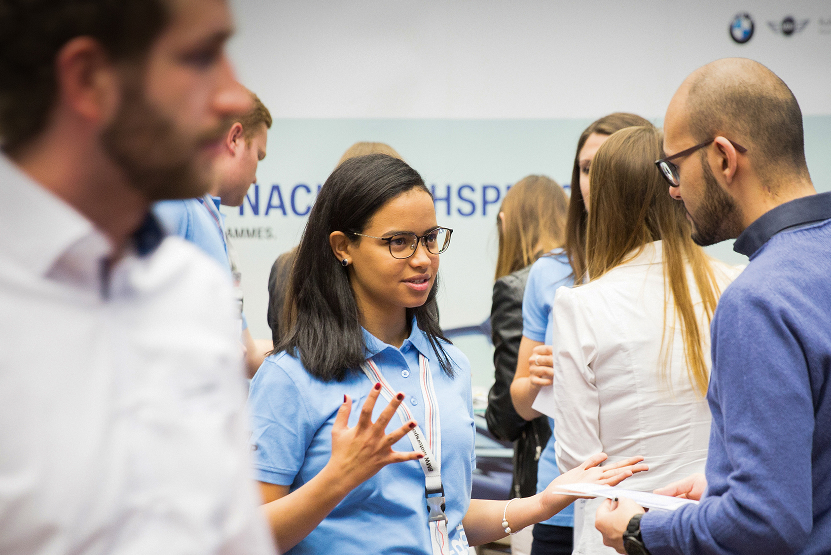 This picture shows some people talking at a BMW recruiting event.