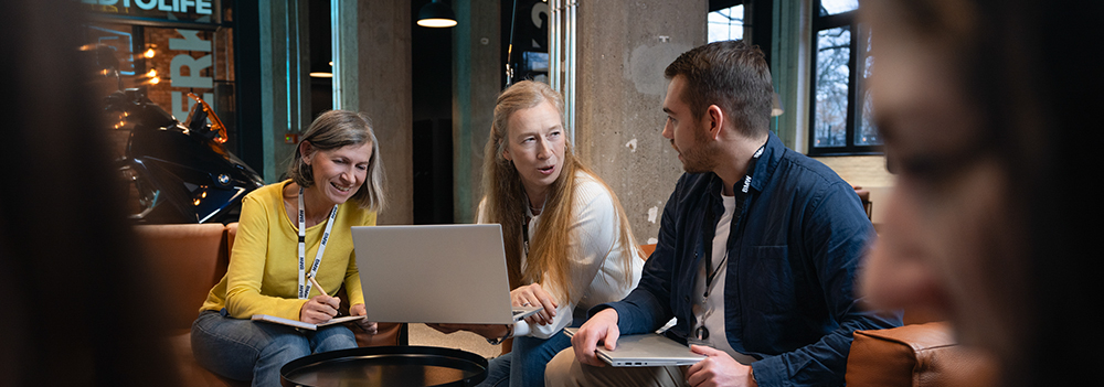 A modern work environment at BMW featuring colleagues working together with technology.