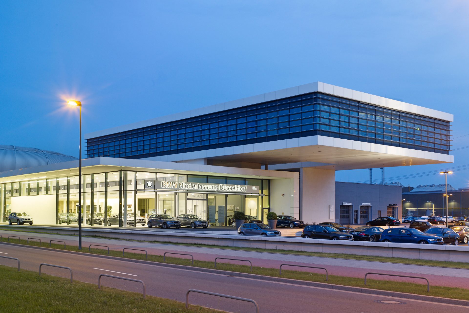 Exterior view of the BMW retail centre in Düsseldorf at night, showcasing modern architecture.