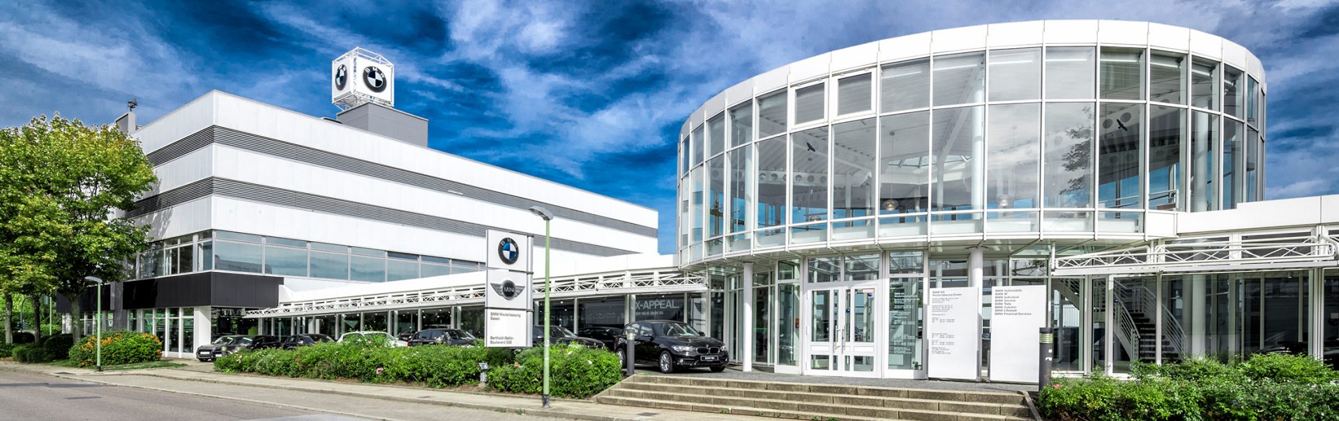BMW and MINI retail centre in Essen with modern architecture and cars.