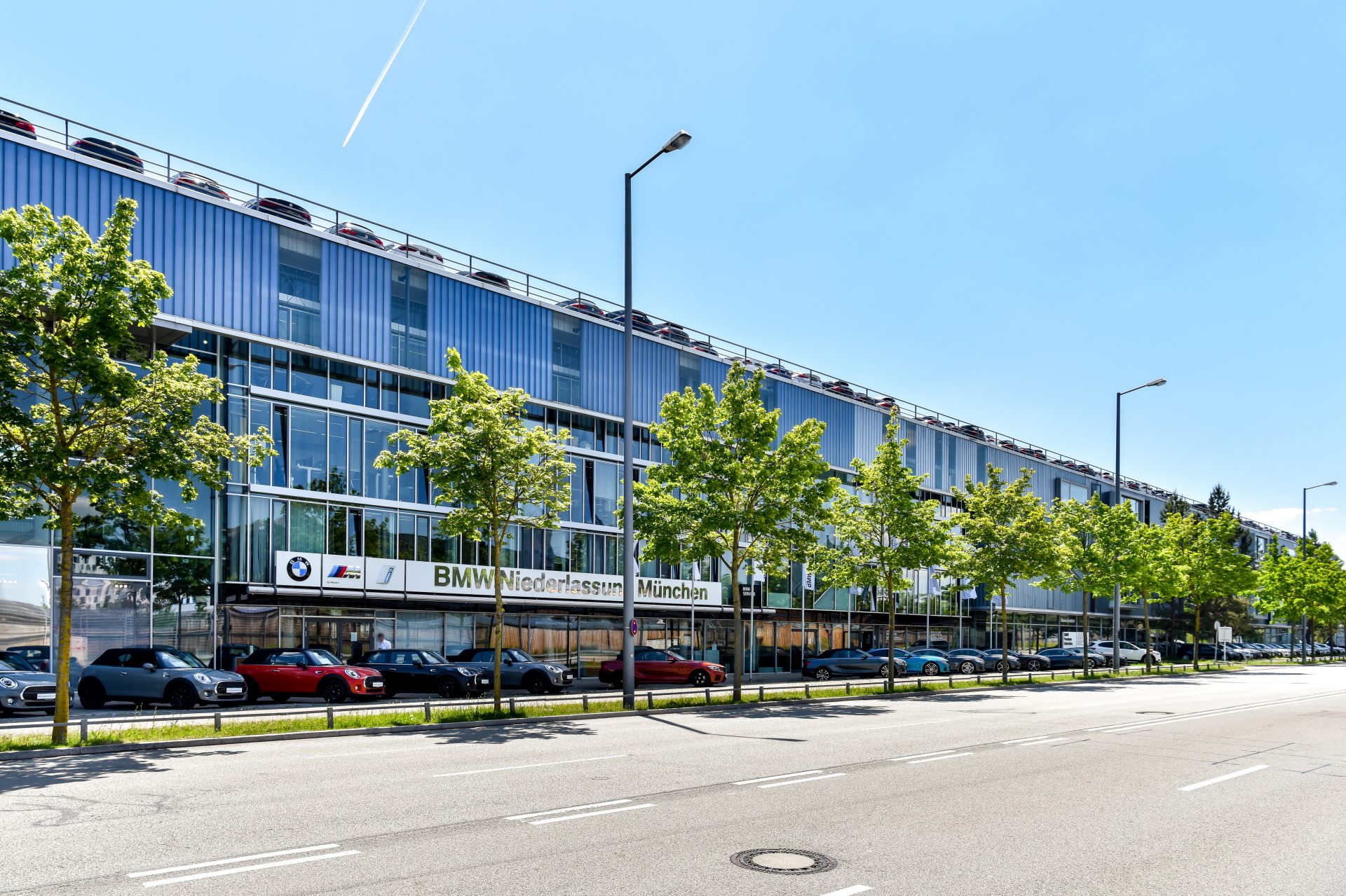 Exterior view of the BMW dealership in Munich with various cars parked outside.
