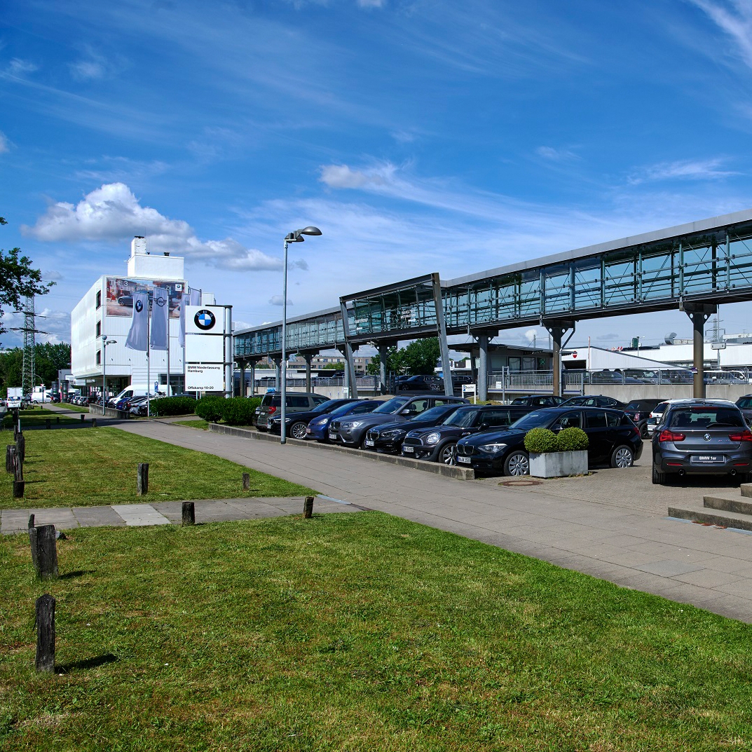 Exterior view of the BMW and MINI showroom in Hamburg with parked cars.
