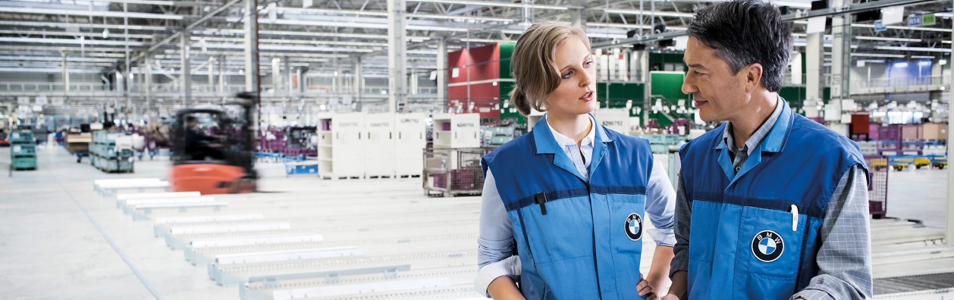 Two BMW employees in conversation at the Hodenhagen distribution center.