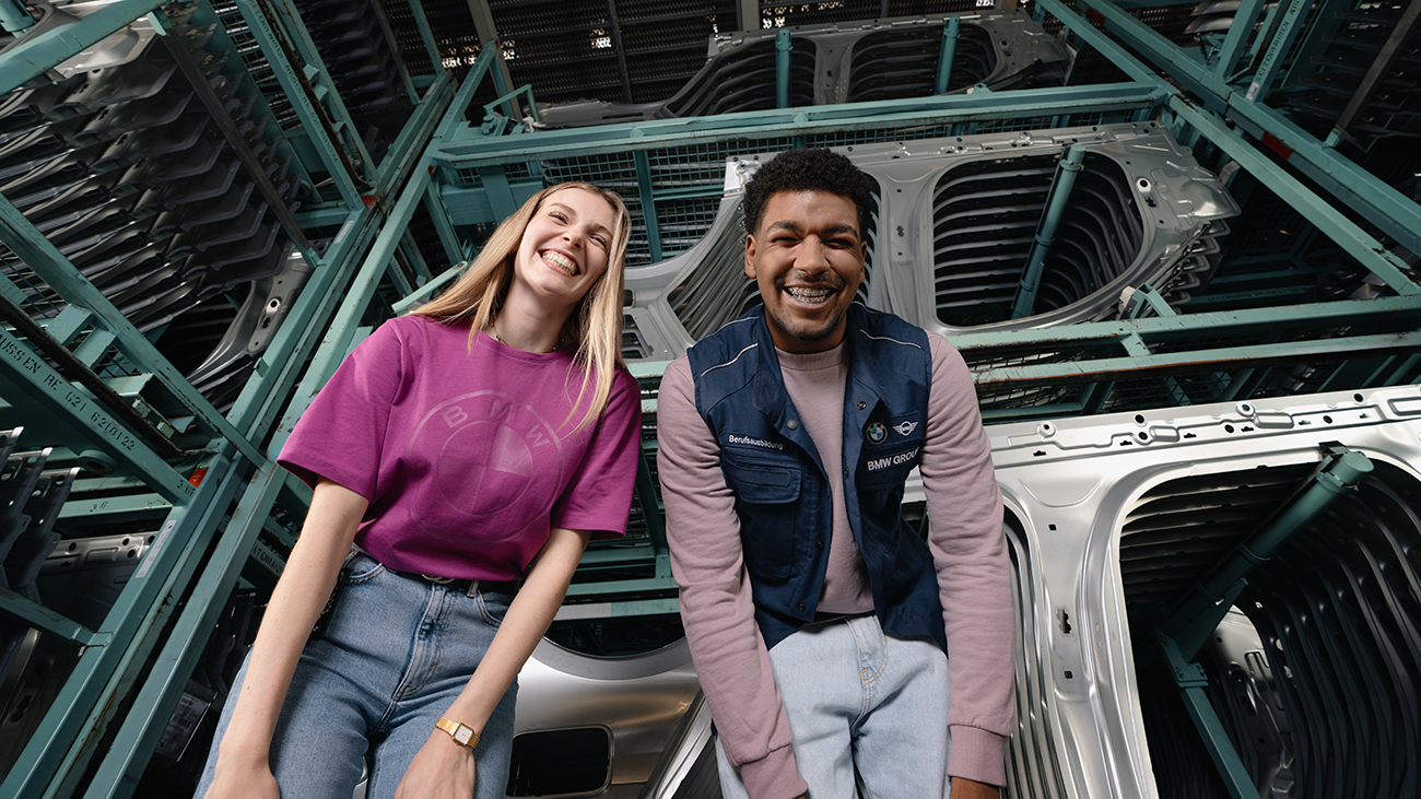 Two BMW Group apprentices are laughing together in a workshop. Aerial view of the BMW Group Plant Eisenach.