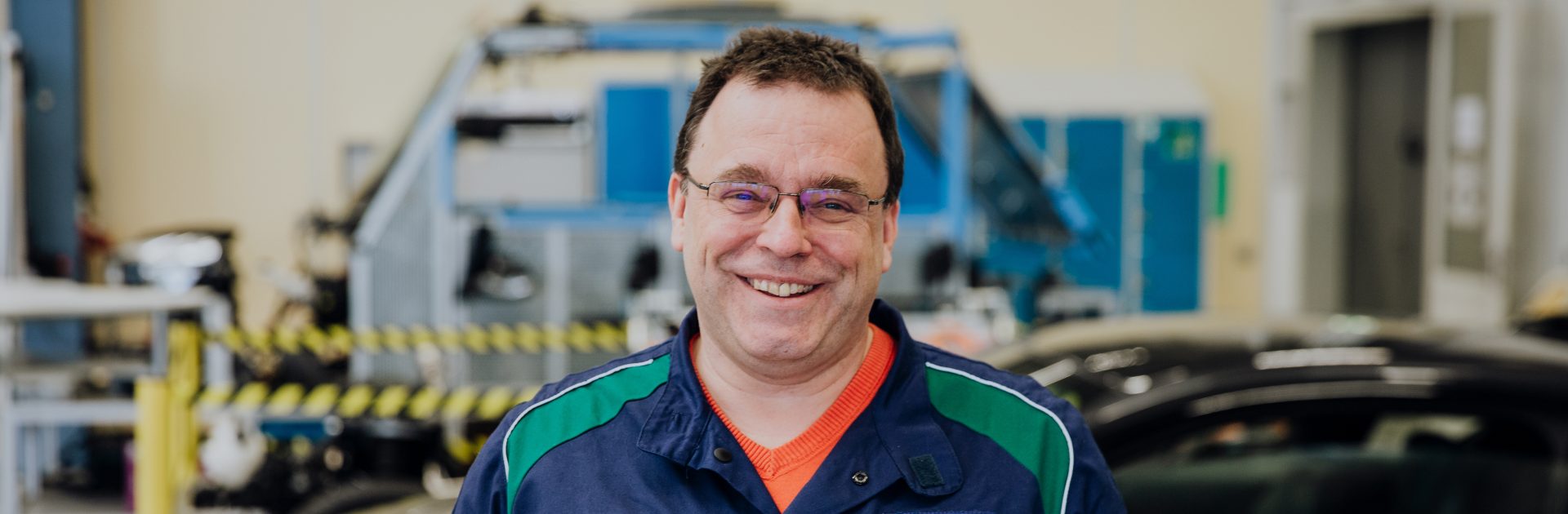 Automotive mechatronics trainer is smiling at the camera.