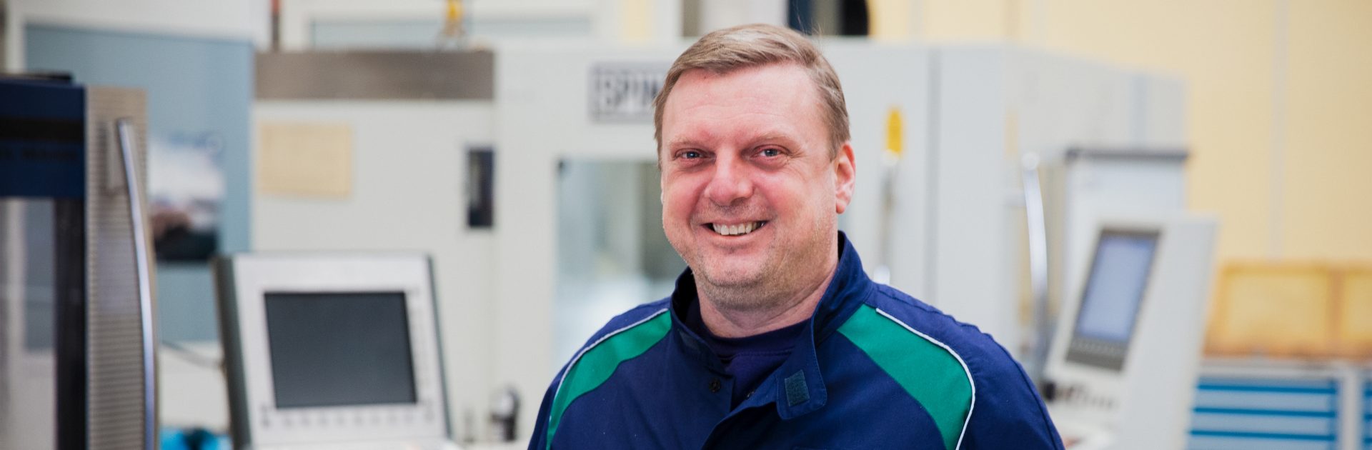 A friendly smiling trainer in the field of metal