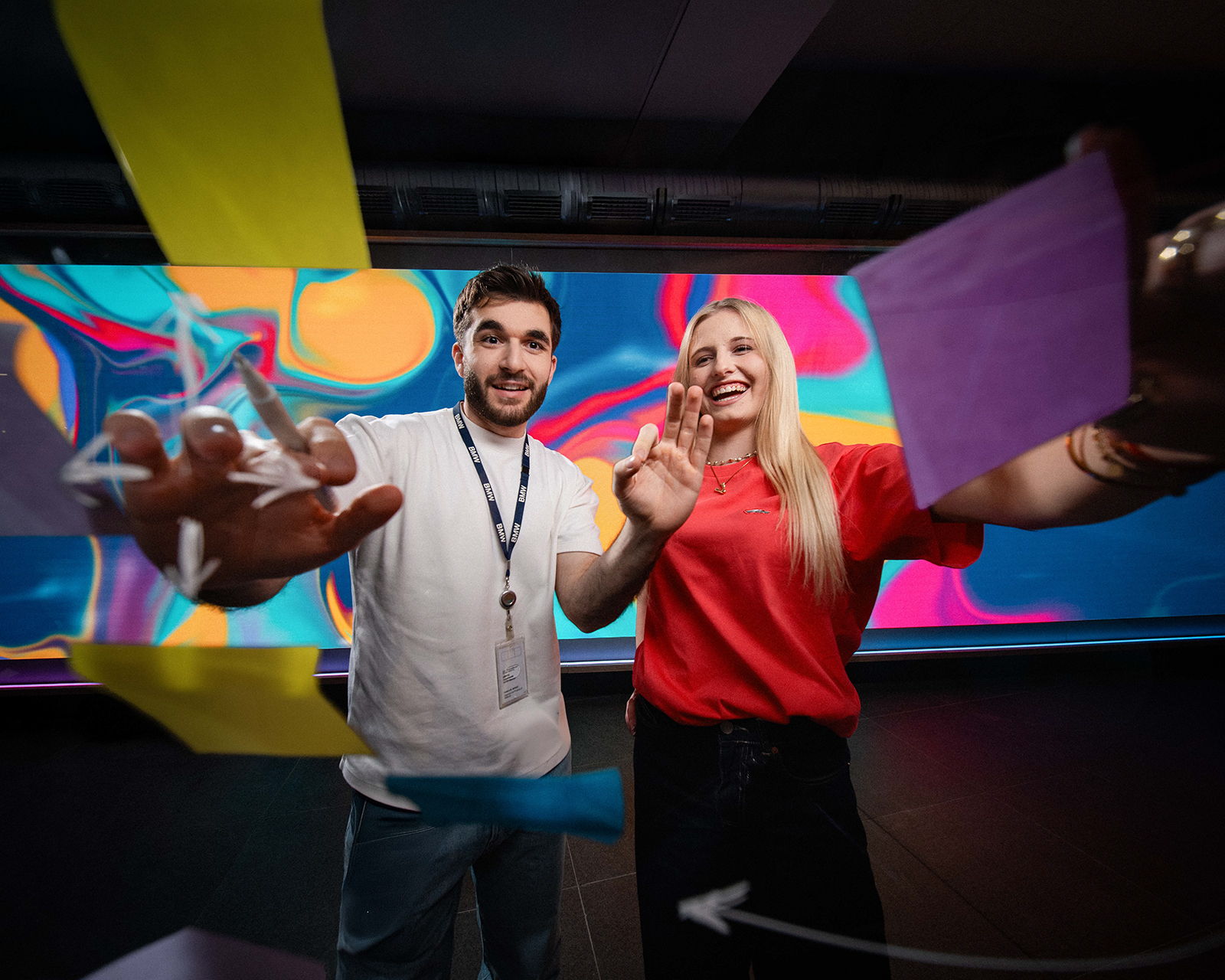 Two trainees working with sticky notes on a glass pane