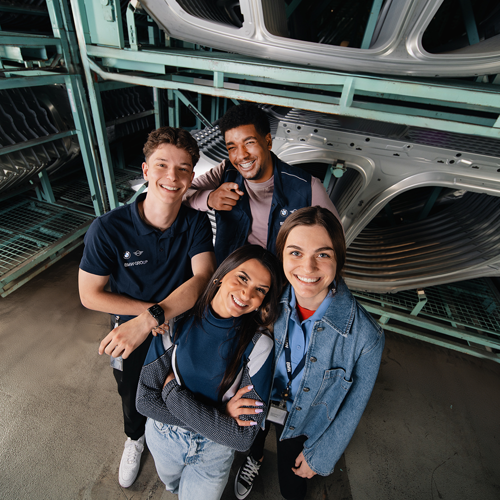 Friendly interaction between young BMW employees in an industrial setting