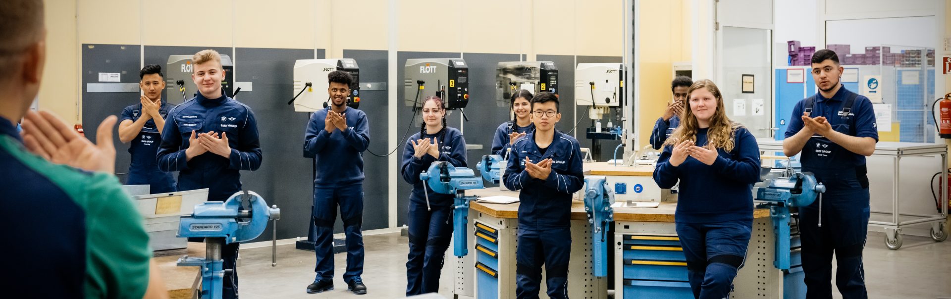 Deaf apprentices in a workshop, actively participating and learning together.