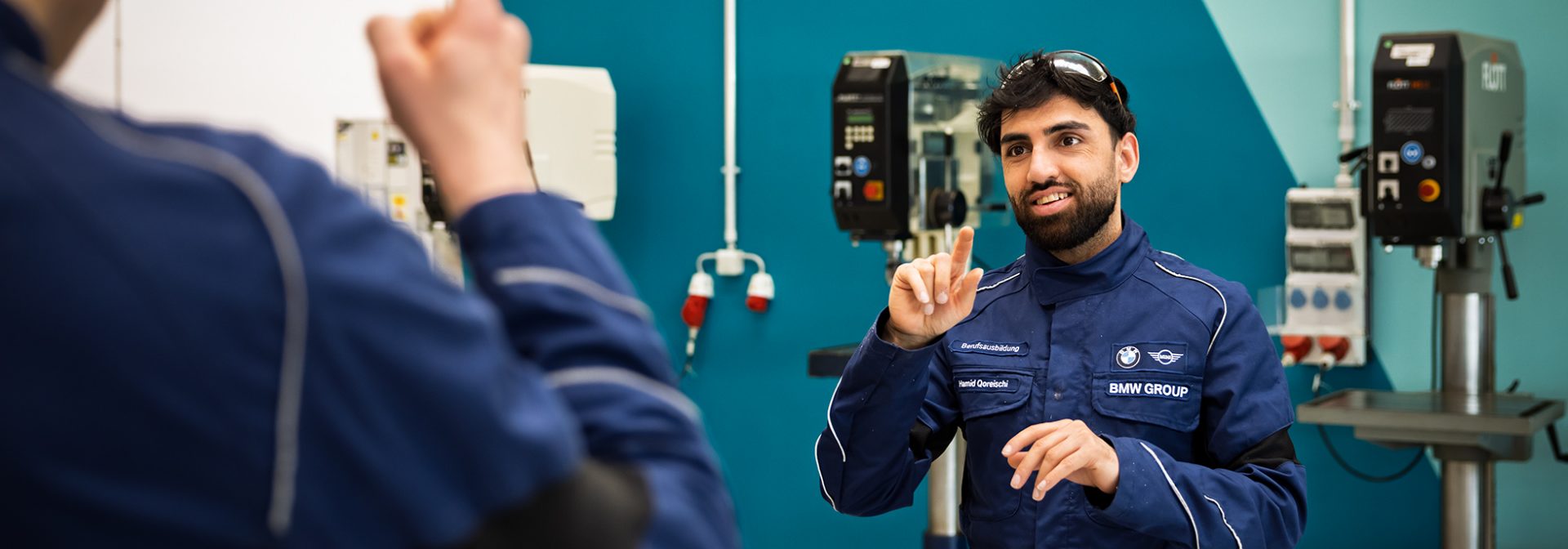 A deaf apprentice having a conversation in sign language with another colleague