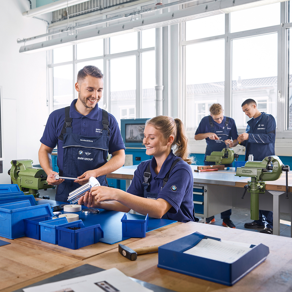 BMW Group apprentices working as tool mechanics in a workshop.