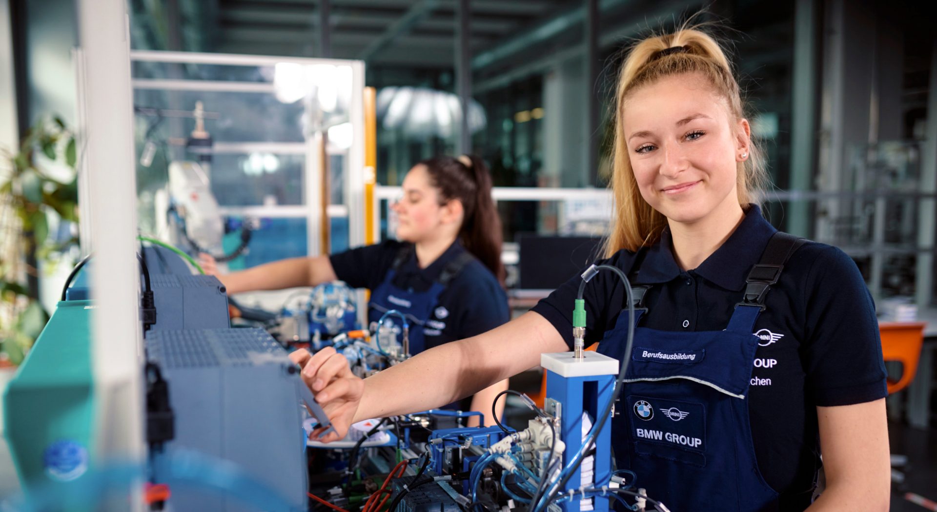 Two female BMW Group apprentices working on automation electronics.