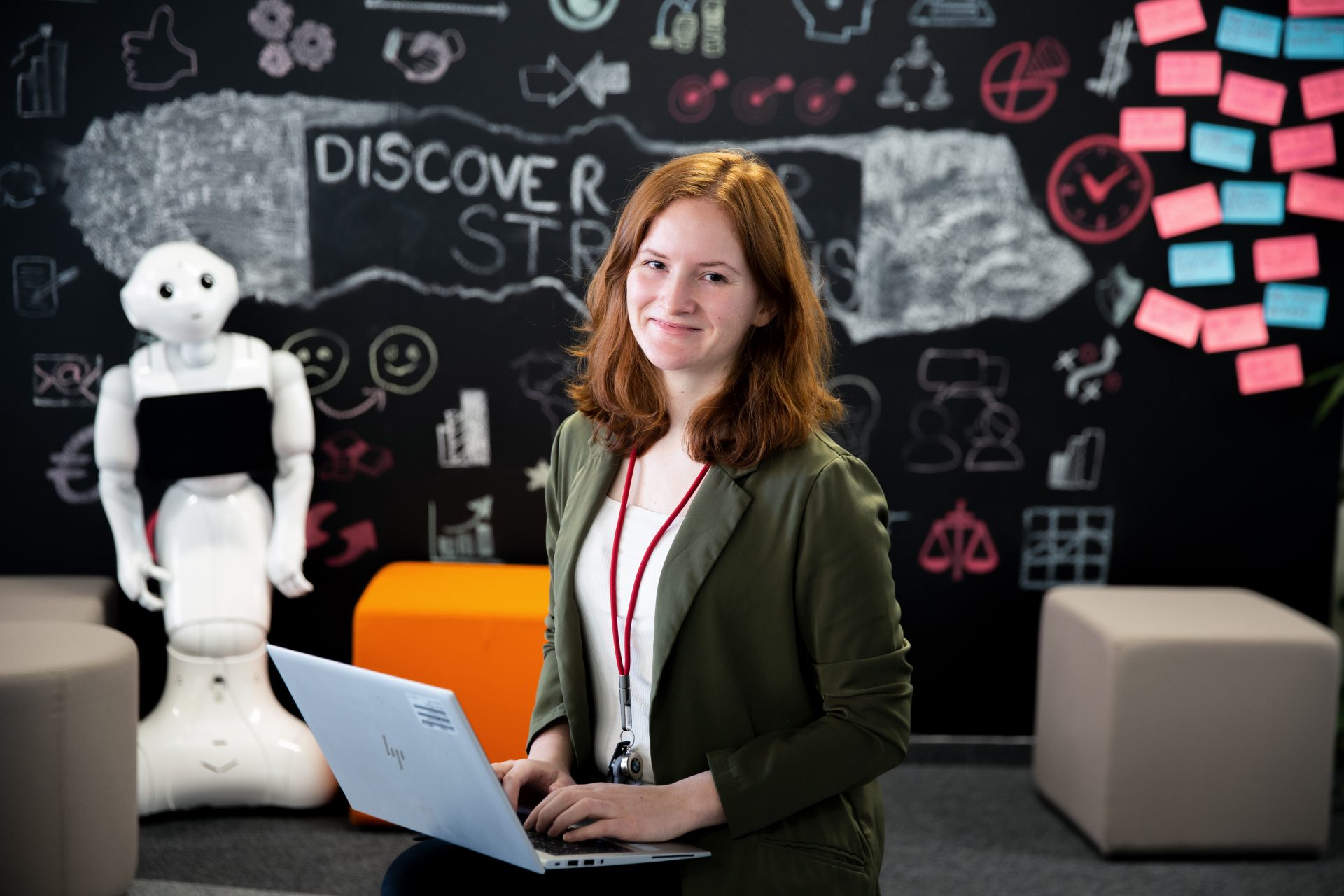 Portrait of trainer Veronika and a robot in the background