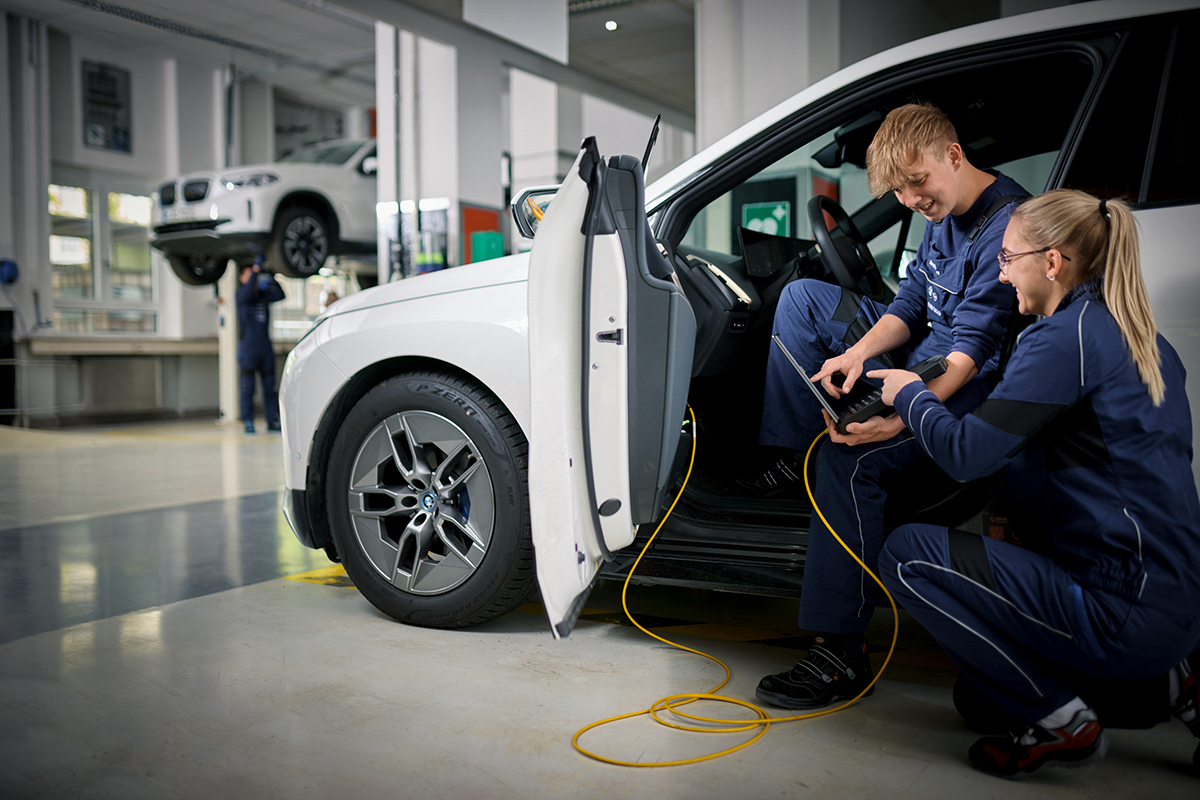 Two apprentice mechatronics engineers at the BMW Group carry out a diagnosis on a vehicle.