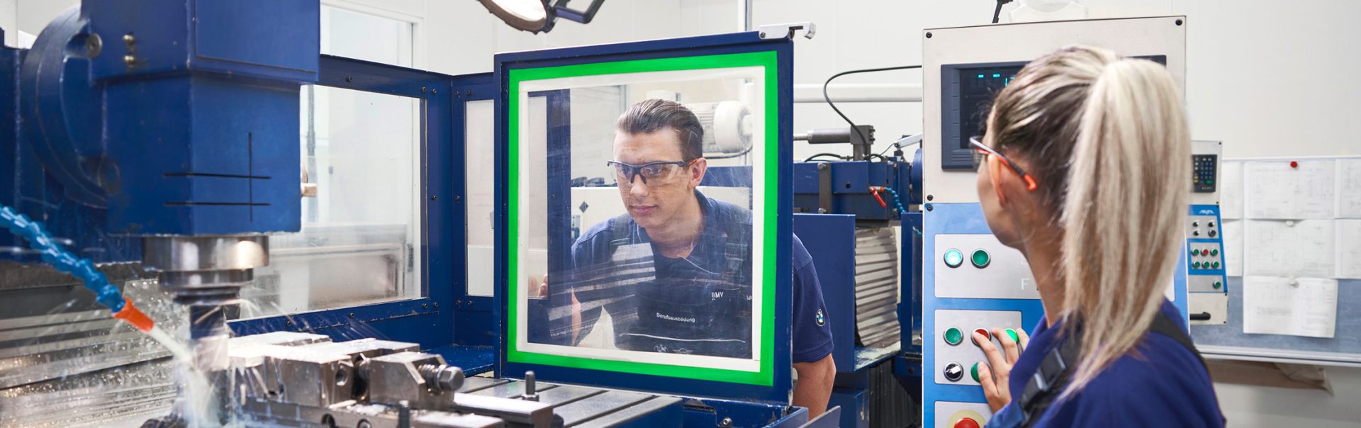  Cutting machine operator at the BMW Group wearing safety goggles while working on a CNC machine.