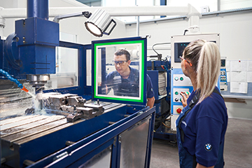  Cutting machine operator at the BMW Group wearing safety goggles while working on a CNC machine.