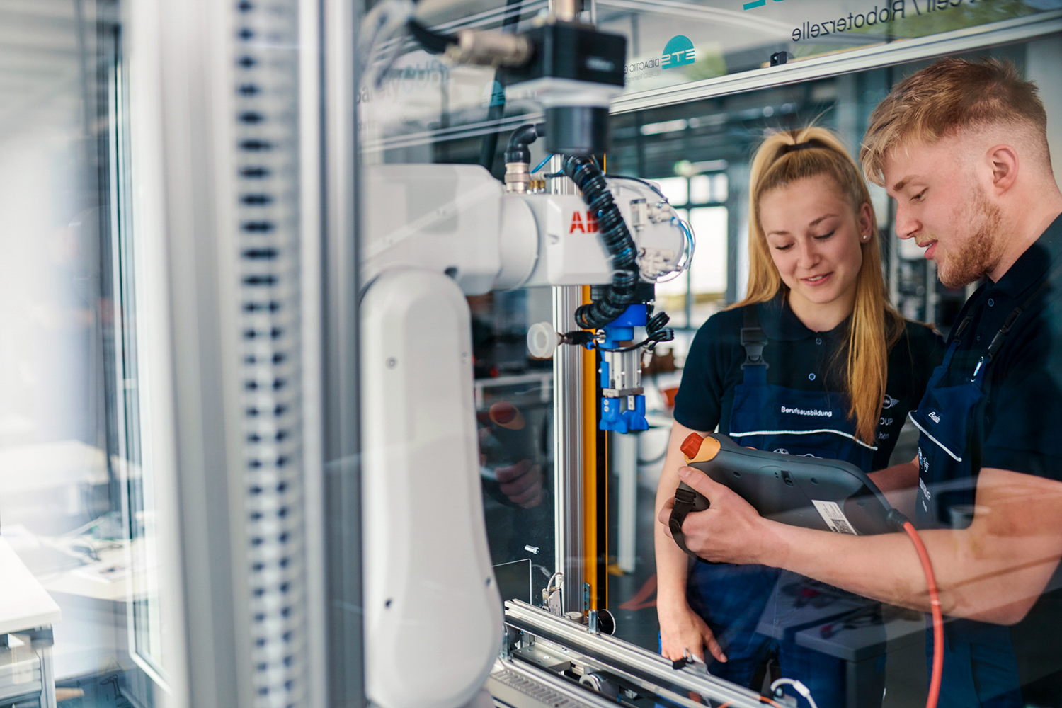 Zwei Mechatronik-Azubis bei der Arbeit an einer Maschine